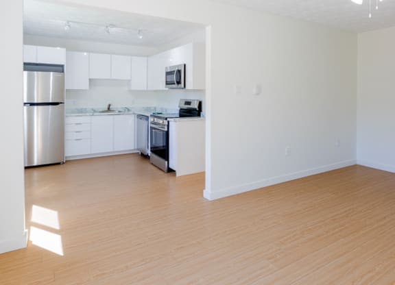 A kitchen with white cabinets and a stainless steel refrigerator.
