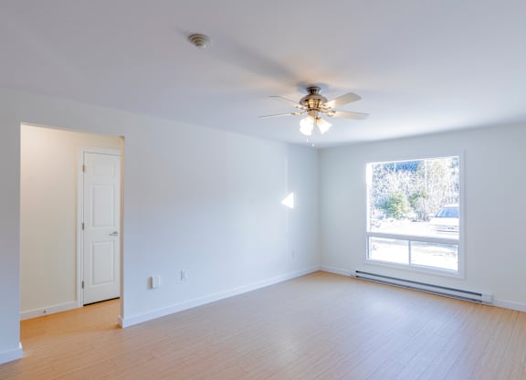 A room with a ceiling fan and a window.
