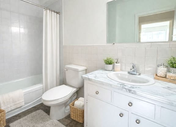 A white toilet sits next to a white sink in a bathroom.
