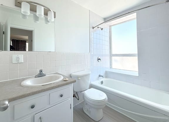 A white bathroom with a sink, toilet, and bathtub.