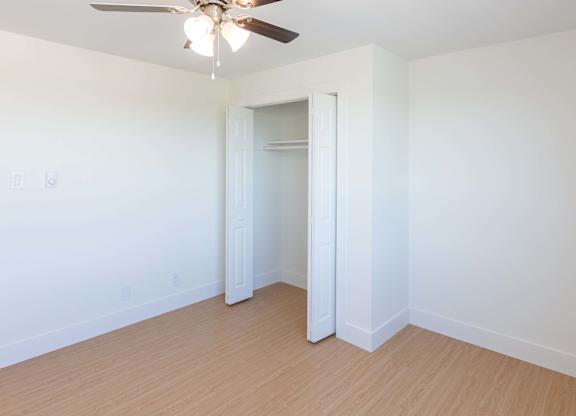A room with a ceiling fan and light fixture.