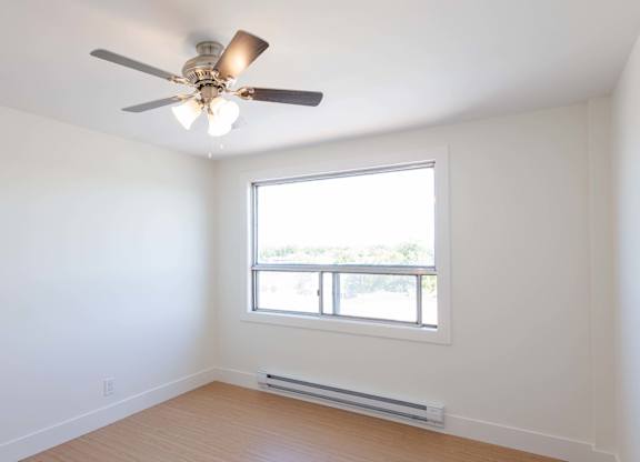 A room with a ceiling fan and a window.