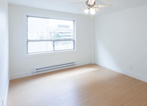 A room with a ceiling fan and a window.