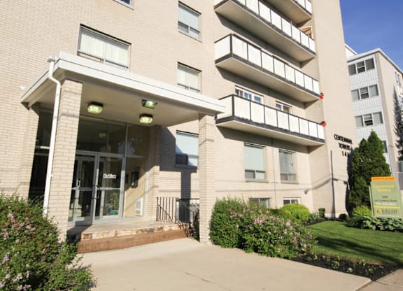A large apartment building with a green lawn in front.