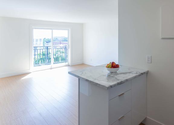 A kitchen with a marble countertop and a bowl of fruit on it.