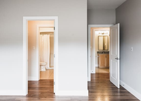 A hallway with two open doors leading to bathrooms.