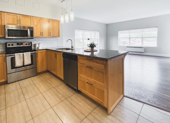 A kitchen with wooden cabinets and a black countertop.