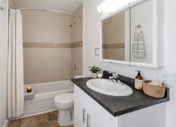 A bathroom with a white toilet, a sink, and a shower.