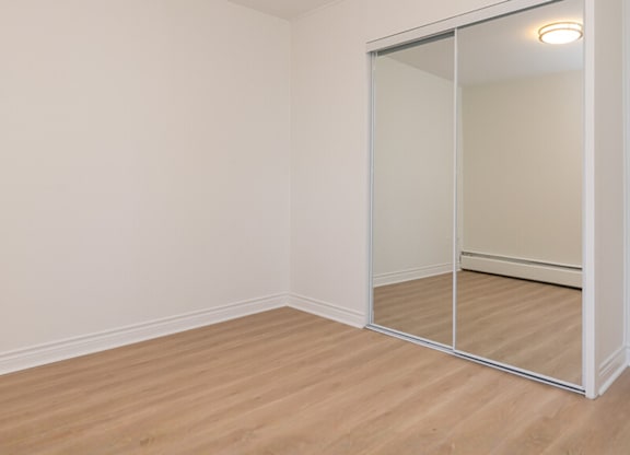 A room with a sliding glass door and wooden flooring.