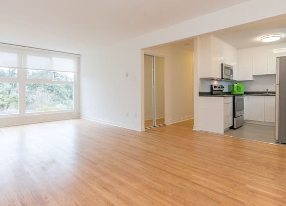 A kitchen with white cabinets and a wooden floor.