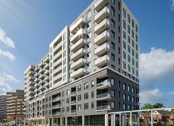 A modern multi-story building with balconies and large windows.