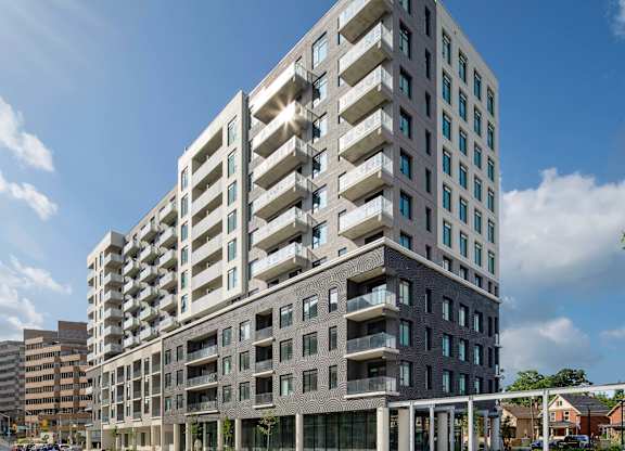 A modern multi-story building with balconies and large windows.