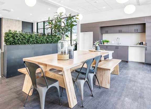 A modern dining area with a wooden table and chairs.