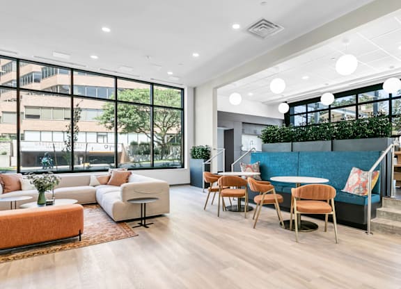 A modern living room with a large window and a view of a building outside.