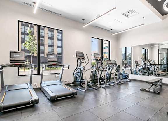 A spacious gym with treadmills, elliptical machines, and other exercise equipment.