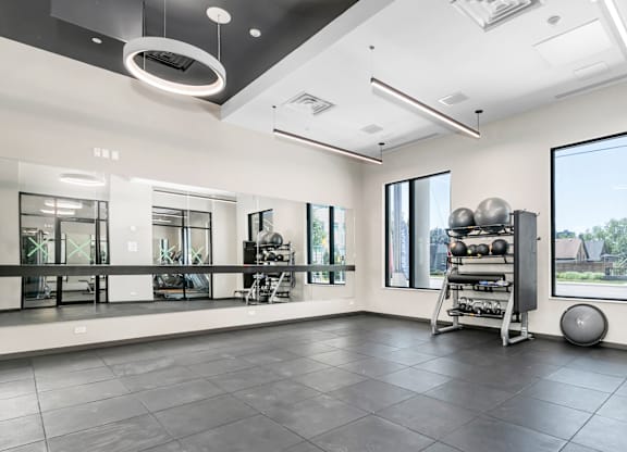 A spacious room with a black floor and white walls, equipped with gym equipment.