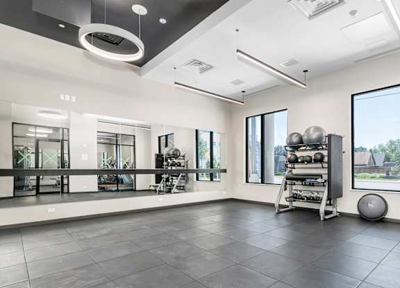 A spacious room with a grey floor and a large window on the right side.