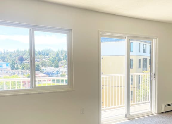 A room with a view of a residential area through the window.
