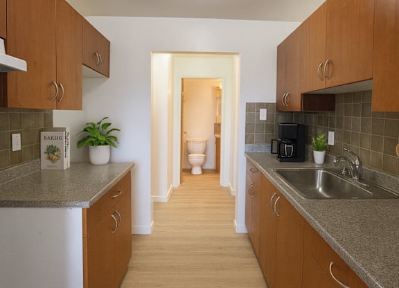 A kitchen with brown cabinets and a white refrigerator.