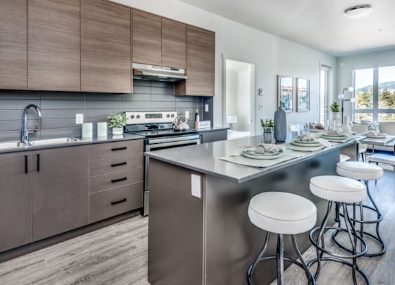 A modern kitchen with a large island and bar stools.