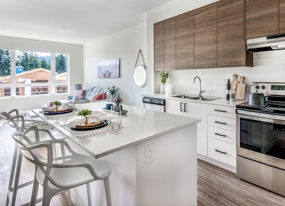 A modern kitchen with a dining table set for two.