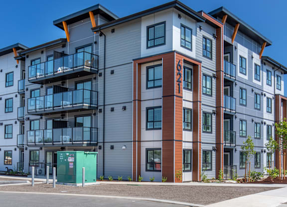 A modern apartment building with a mix of grey, brown, and blue tones.