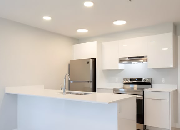 A modern kitchen with white cabinets and appliances.