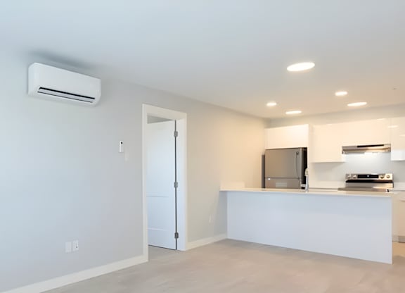 A modern kitchen with a white countertop and a stainless steel refrigerator.