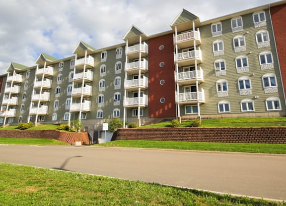 Apartment building with a red door on the side.