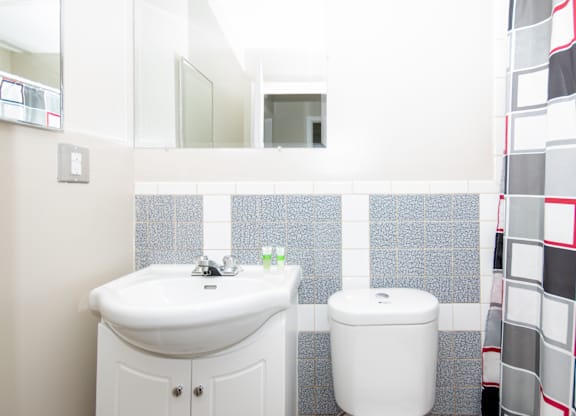 A white sink and toilet in a bathroom with a mirror above it.