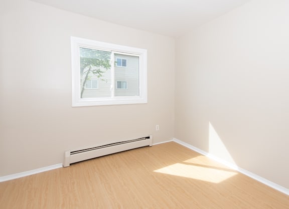A room with a window and a radiator on the wall.