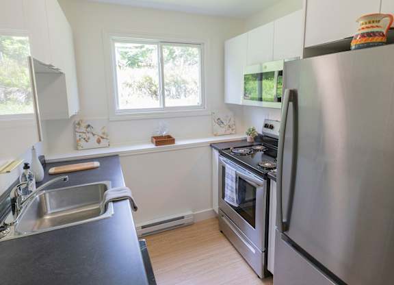 A modern kitchen with a stainless steel refrigerator and oven.