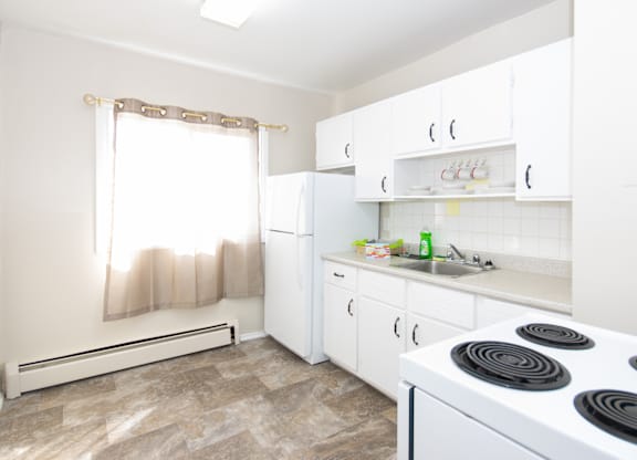 A kitchen with white appliances and cabinets.