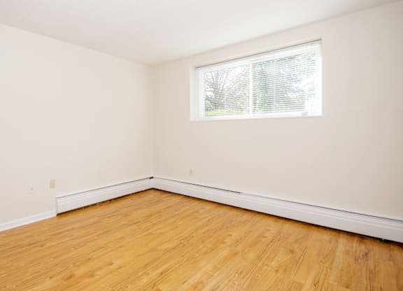 Empty room with wooden floor and white walls.