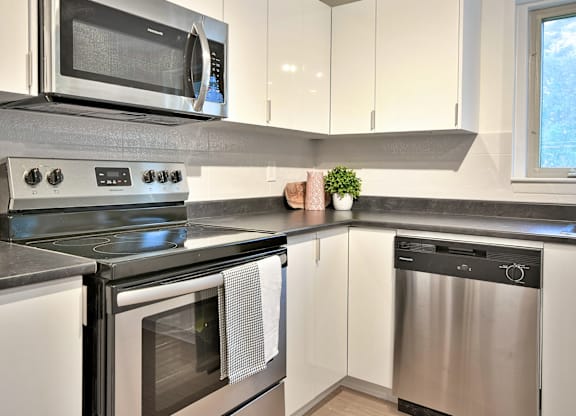 A modern kitchen with a stainless steel dishwasher and oven.