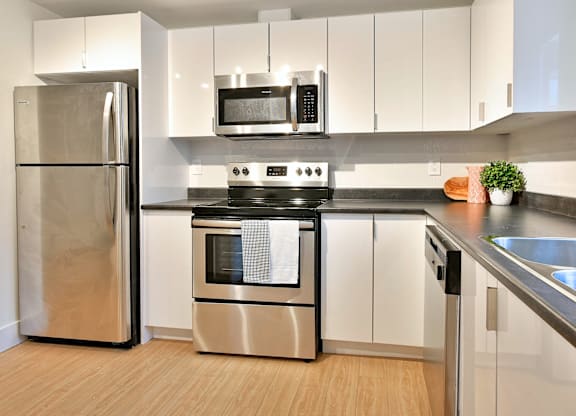 A modern kitchen with a stainless steel refrigerator and oven.