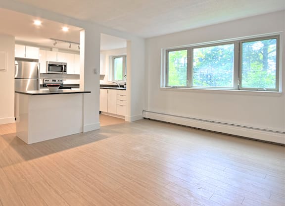 A kitchen with a refrigerator, microwave, and oven.