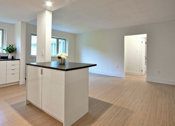 A kitchen with white cabinets and a black countertop.