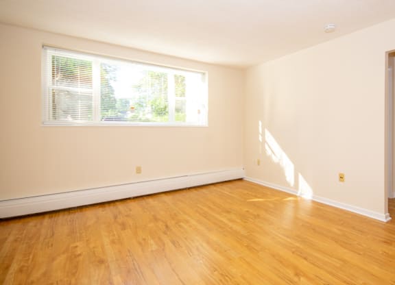 A room with a window and wooden floors.