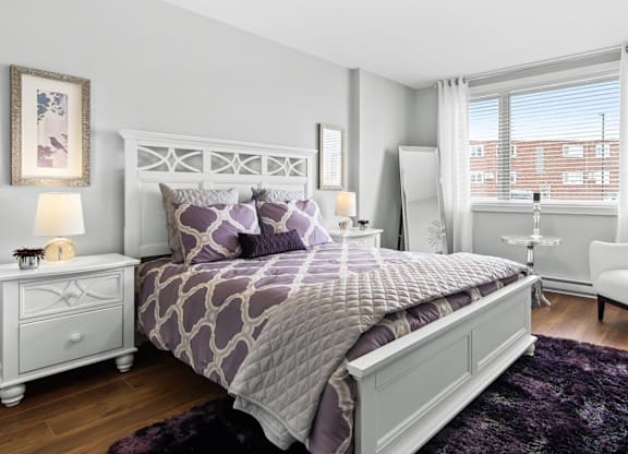 A bedroom with a large bed and a white dresser.