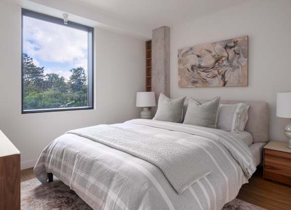 A bedroom with a large bed and a painting on the wall.