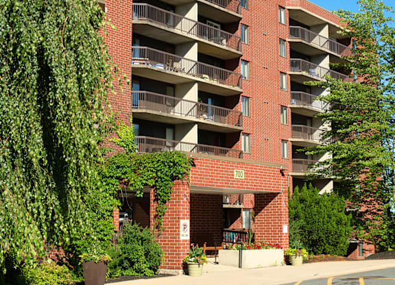 A red brick building with balconies and a parking sign.