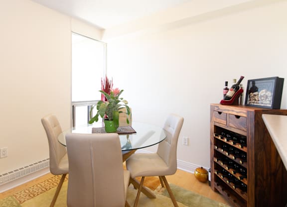 A dining room with a glass table and chairs.