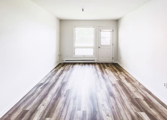 A room with a wooden floor and white walls.