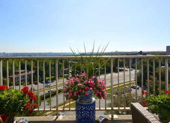 A balcony with a view of the street and buildings.