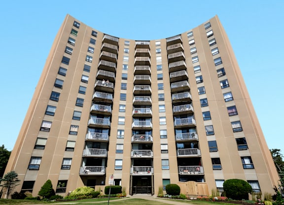 A tall, curved building with balconies on each floor.