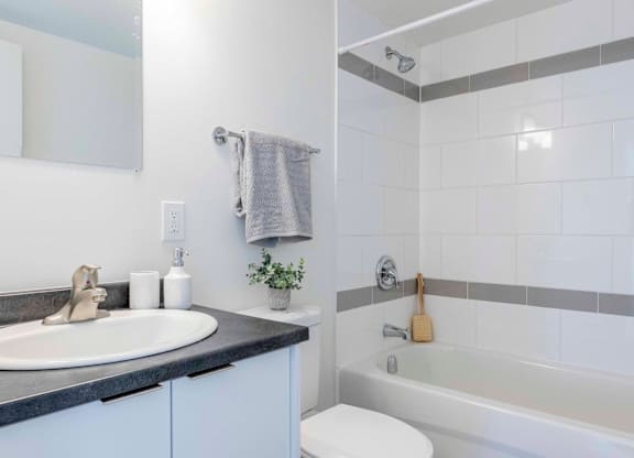 A bathroom with a white toilet, a sink, and a bathtub.