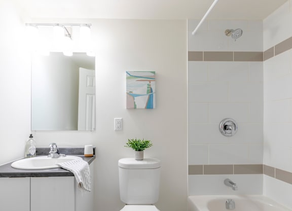 A white toilet sits next to a white sink in a bathroom.