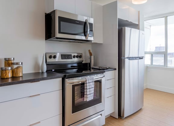 A modern kitchen with a stove, oven, and refrigerator.