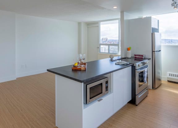 A kitchen with a black countertop and white cabinets.
